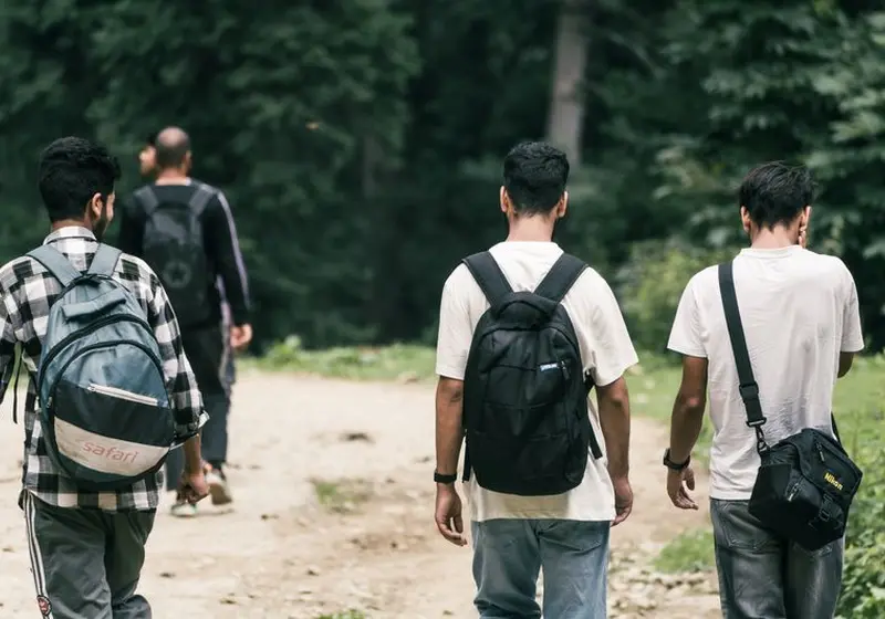 Group of travelers with backpacks on a forest trail